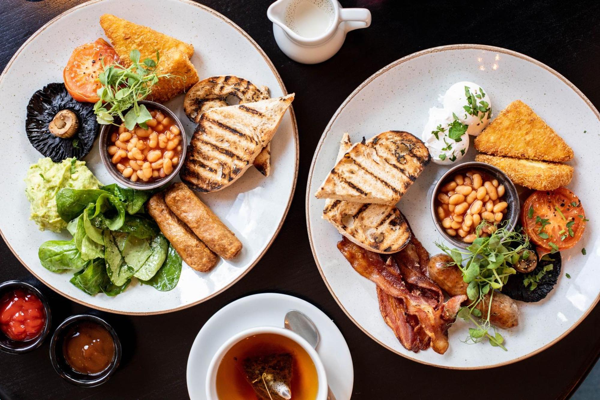 Citysuites 2 Aparthotel Manchester Kültér fotó The photo displays two plates of hearty breakfast items. Each plate includes:

- Grilled bread slices
- Grilled sausages
- Baked beans served in a small bowl
- Fresh salad with greens
- A slice of tomato
- A piece of grilled mushroom
- Crispy bacon s