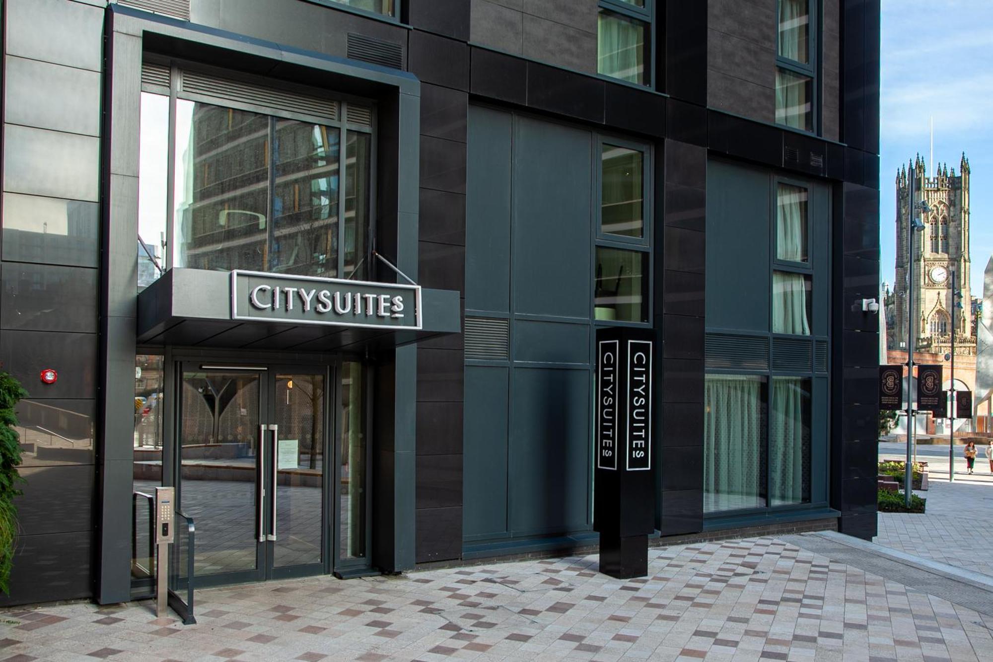 Citysuites 2 Aparthotel Manchester Kültér fotó The photo shows the entrance to a modern building labeled "CITYSUITES." The entrance features large glass doors and a sleek, contemporary design. The building has dark exterior panels and large windows, suggesting a stylish and urban environment. The
